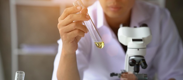 Close up view of industrial worker with vegetable oil quality test in the room