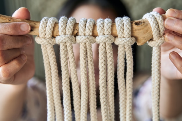 Close up view of a macrame decoration made by hand by a young woman