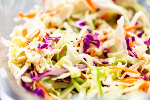 Photo close up view. making homemade coleslaw in a glass bowl.