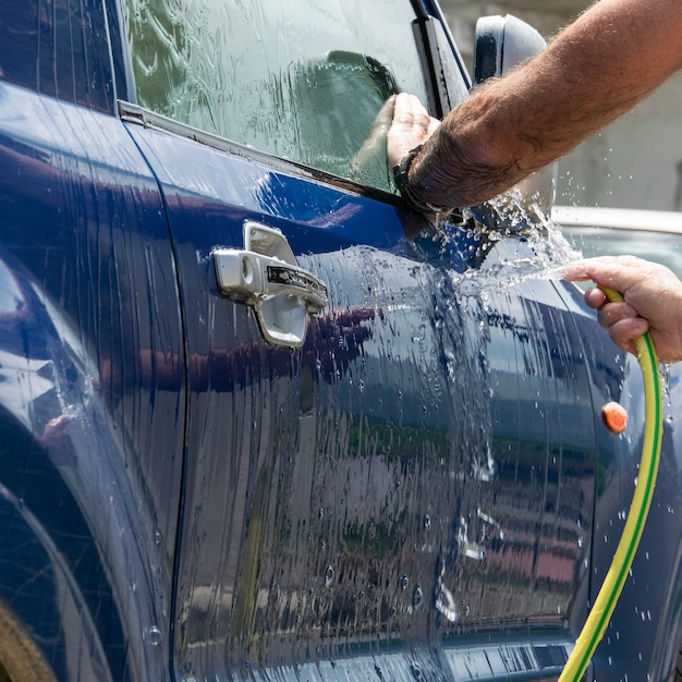 Close up view of man hands washing automobile