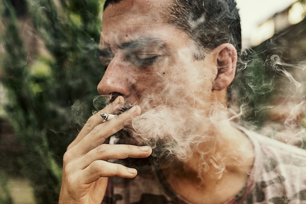 Close up View of Man Smoking Marijuana Cigarette Outdoors