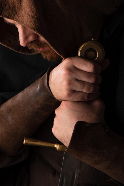 Close up view of medieval Scottish warrior with sword isolated on black