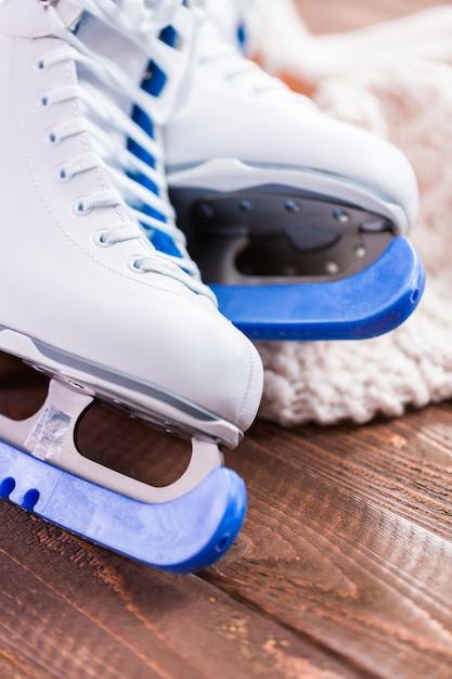 Close up view. New white figure skates on a wooden boards.