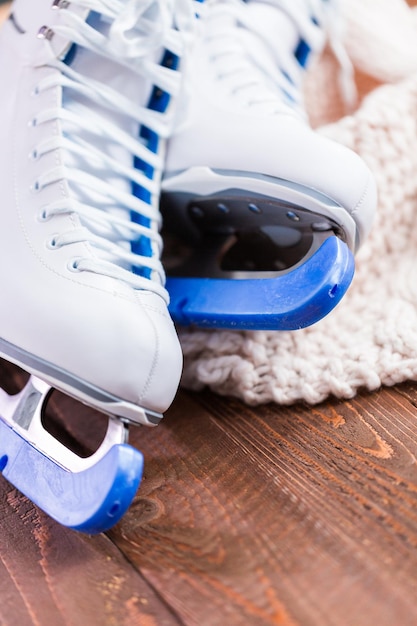 Close up view. New white figure skates on a wooden boards.