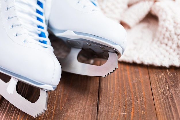 Close up view. New white figure skates on a wooden boards.