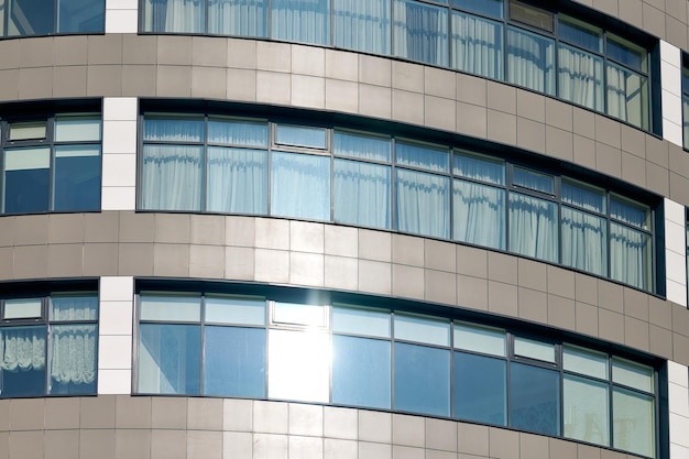 Close up view to office skyscraper windows high business building windows with sunlight glare