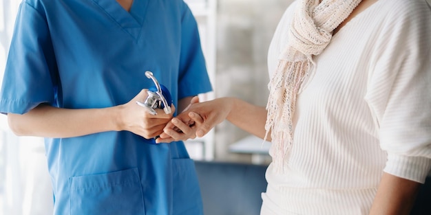 Close up view of old woman leaning on nurse while siting