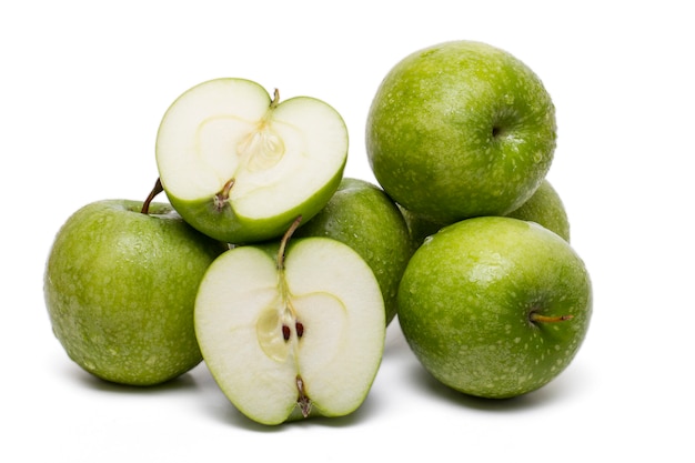 Close up view of a pile of green apples isolated on a white background.