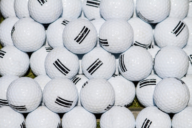 Close up view of a pile of white golf balls.