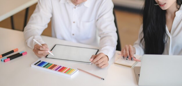 Close-up view of professional designer team drafting the concept on blank screen tablet