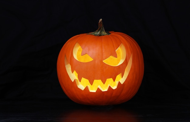 Close up view of scary Halloween pumpkin with eyes glowing inside