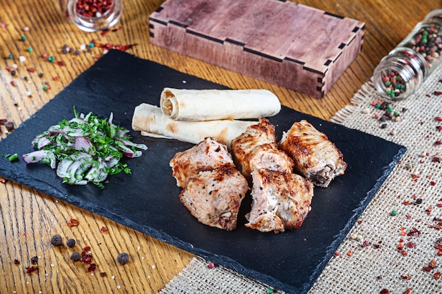 Close up view on served cooked on the grill turkey. shashlik or barbecue meat with pita. Shish kebab, traditional georgian cuisine food. Copy space for design