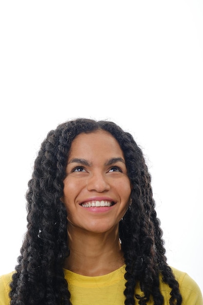 Close up view of a smiling woman looking up while standing over an isolated background.