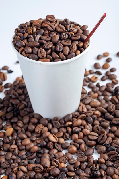 Close up view of a white plastic cup and coffee beans