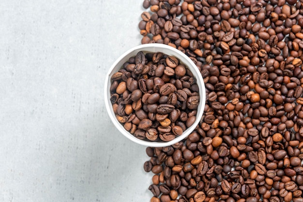 Close up view of a white plastic cup and coffee beans