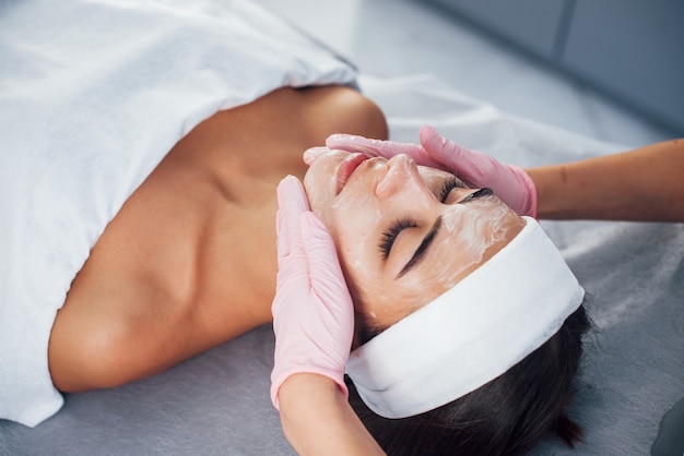 Close up view of woman that lying down in spa salon and have face cleaning procedure by the mask.