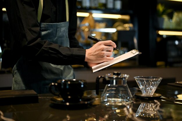 Close up view of young male baristas taking an order for his customer