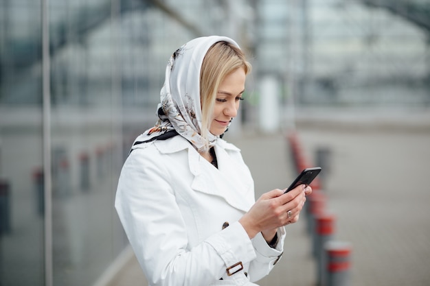 Close up view young woman in a big city using phone