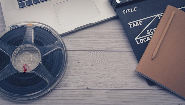 Close up of a vintage clapboard with laptop and filmstrip