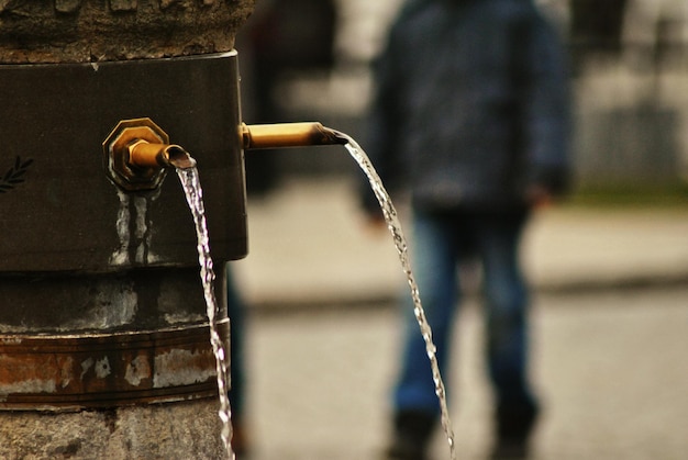 Photo close-up of water falling from metallic structure