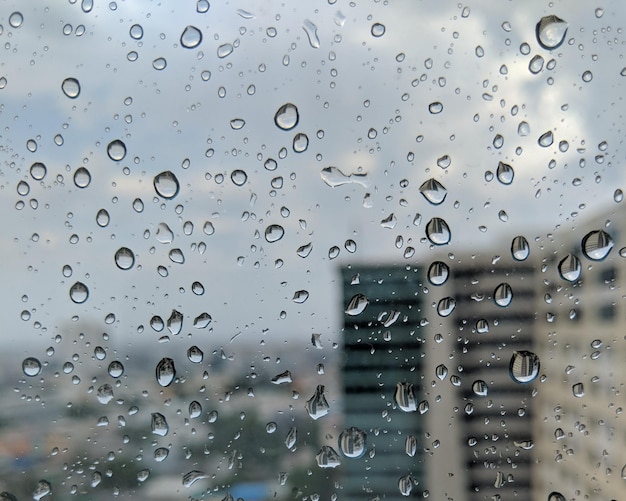 Photo close-up of wet glass window during rainy season