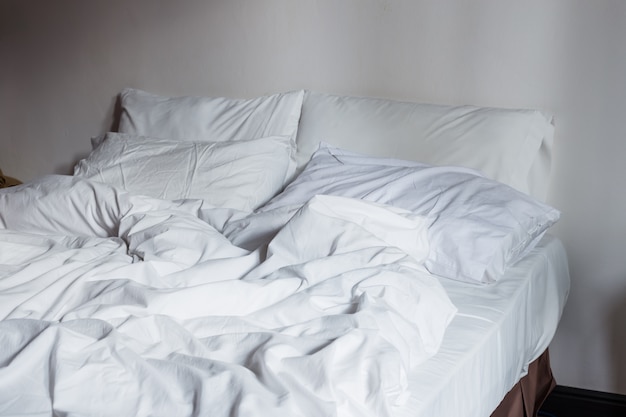 Close up white bedding sheets and pillow, Messy bed concept