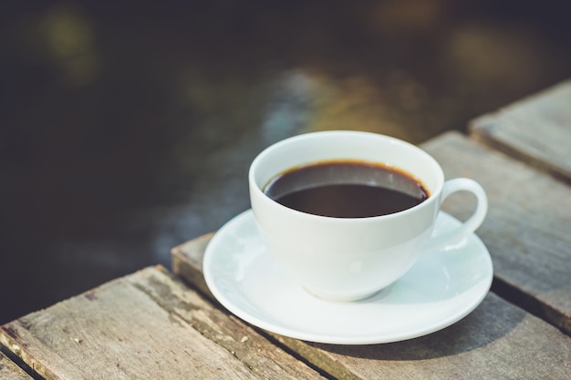 Close up white coffee cup in the garden at morning time 