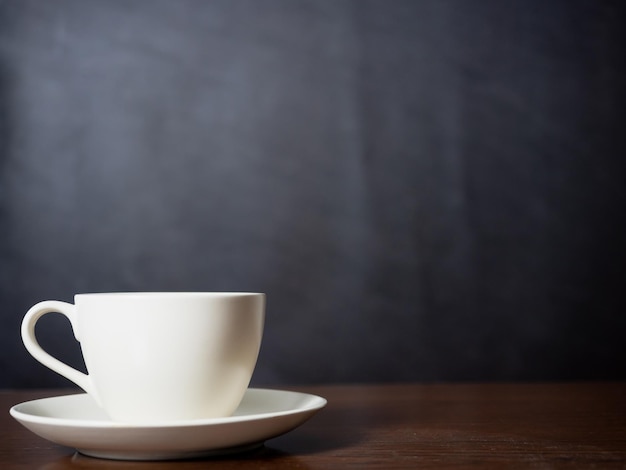 Close up white coffee cup on wood table dark background