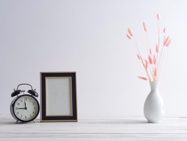 Photo close-up of white flower vase on table against wall