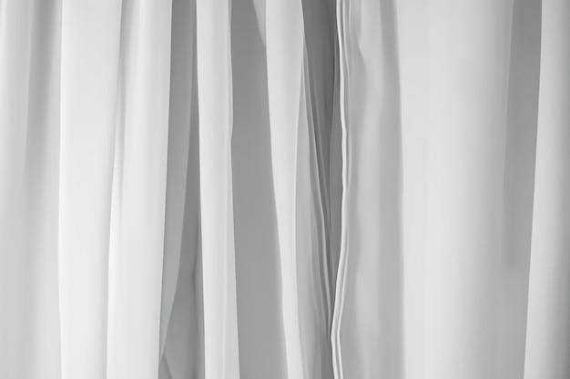 Photo close up of white sheer curtains with soft light filtering through