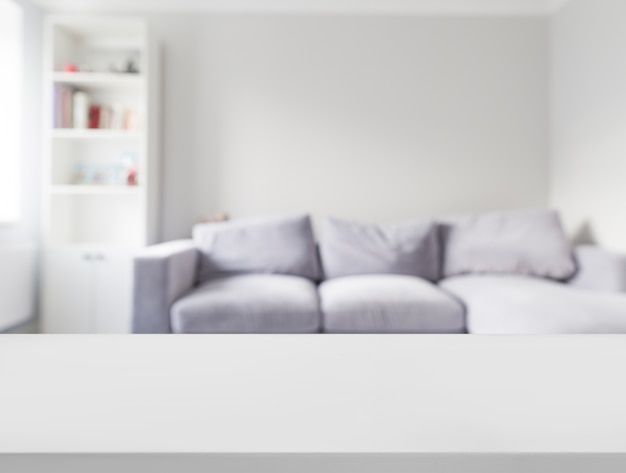 Close-up of white table in front of defocused sofa