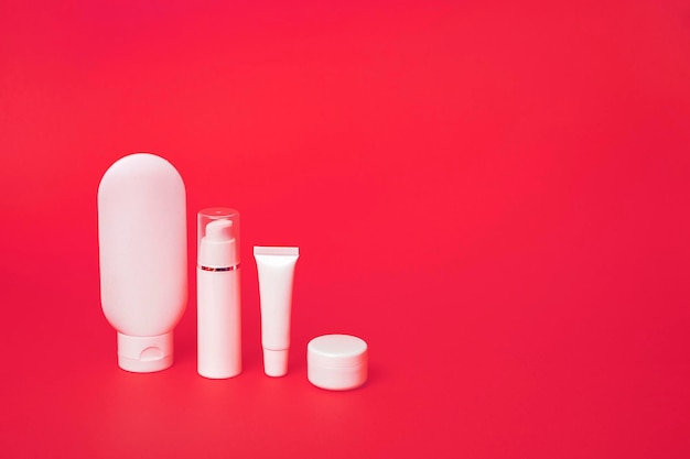 Close up of white tubes for various cosmetics on a pink background With copy space