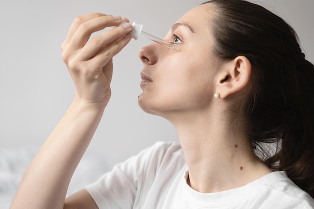 Close up of white woman hand applying oil of essential oil or serum for skin Self care concept