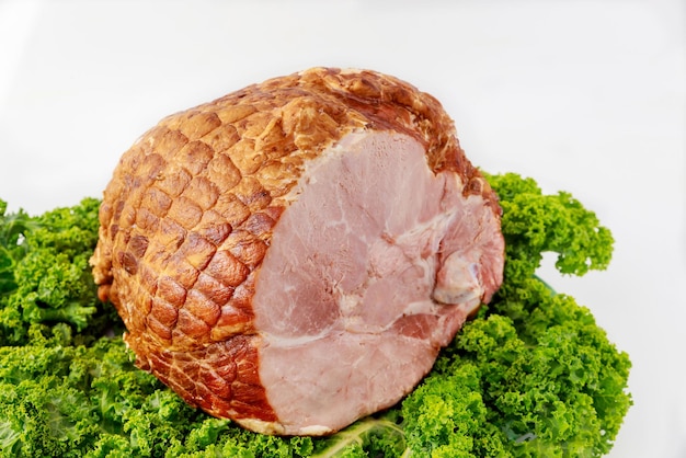 Close up of whole pork ham with fresh kale Healthy food Easter meal