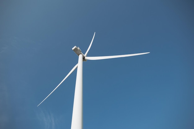 Close up of wind propeller working on field over blue sky