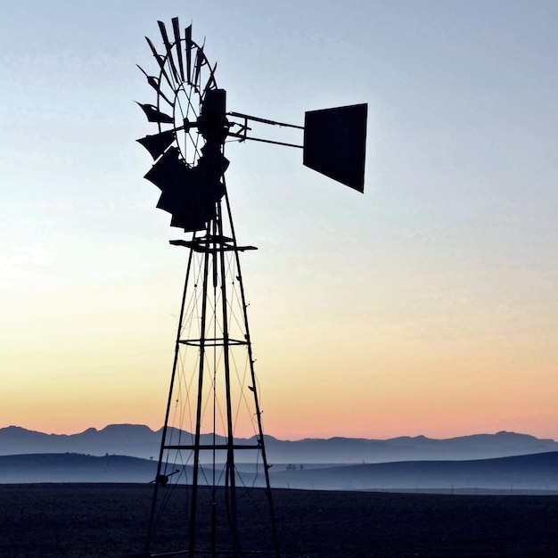 close up of a windmill water pump at sunrise