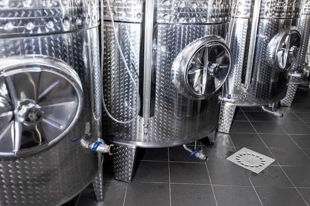 Close up of a wine factory with small steel tanks for storage and fermentation of arrenge of wine al