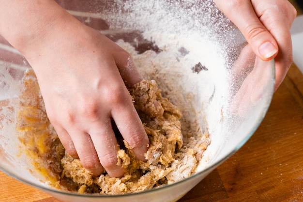 Close up of woman baker hands kneading the dough in the mixing bowl homemade pastry for cakes or coo