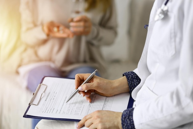 Close-up of woman-doctor and  patient discussing current health examination while sitting indoors. Stay at home concept during Coronavirus pandemic and self isolation quarantine. Covid 2019.