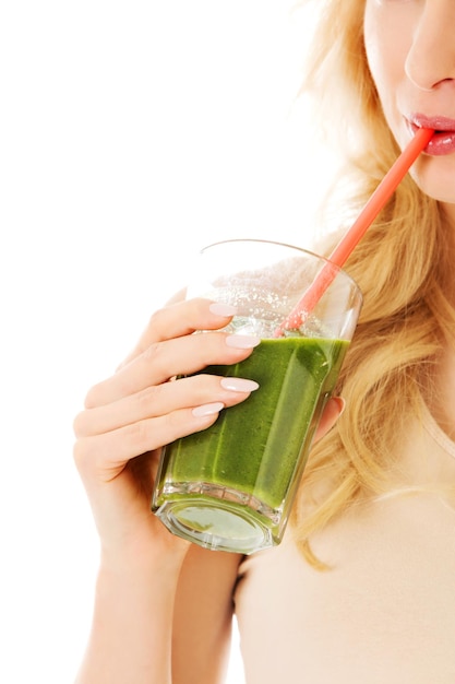 Close-up of woman drinking juice against white background