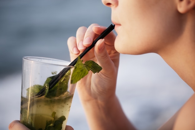 Close up of woman enjoying an evening cocktail