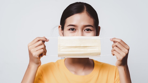 Close up woman face holding face mask for protection from virus.