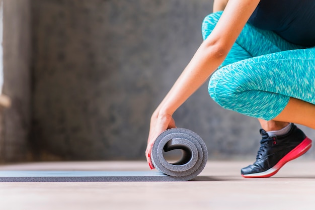 Close-up of a woman folding yoga mat