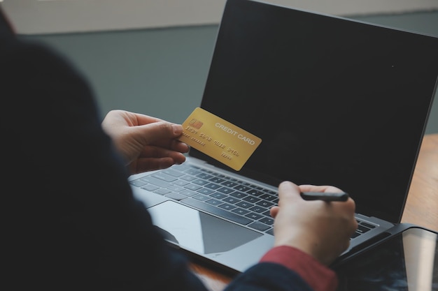 Close up of woman hand using credit card and laptop for payment and online shopping Online shopping payments digital banking Ecommerce concept