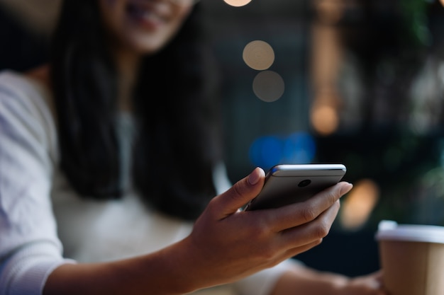 Close up woman hand using smart phone, downloading mobile app for online shopping. Girl chatting, reading news