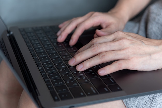 Close up woman hand working or typing on laptop