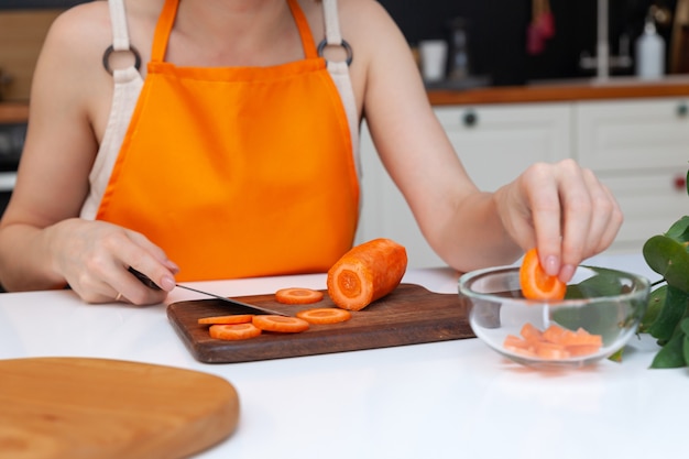 Close-up woman hands chopping cucumber vegetables by knife