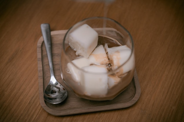 Close up Woman Hands is Pouring Milk into The Cold Lemon Tea or Coffee for Cold Brew Menu