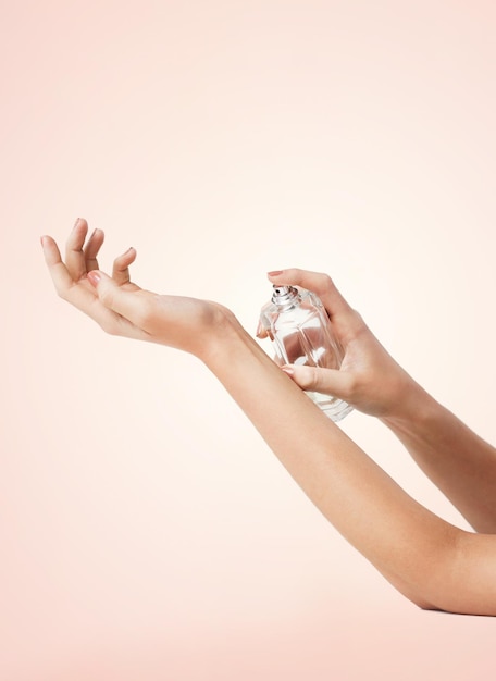 close up of woman hands spraying perfume