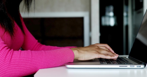 Close up of woman hands typing on laptop computer keyboard.